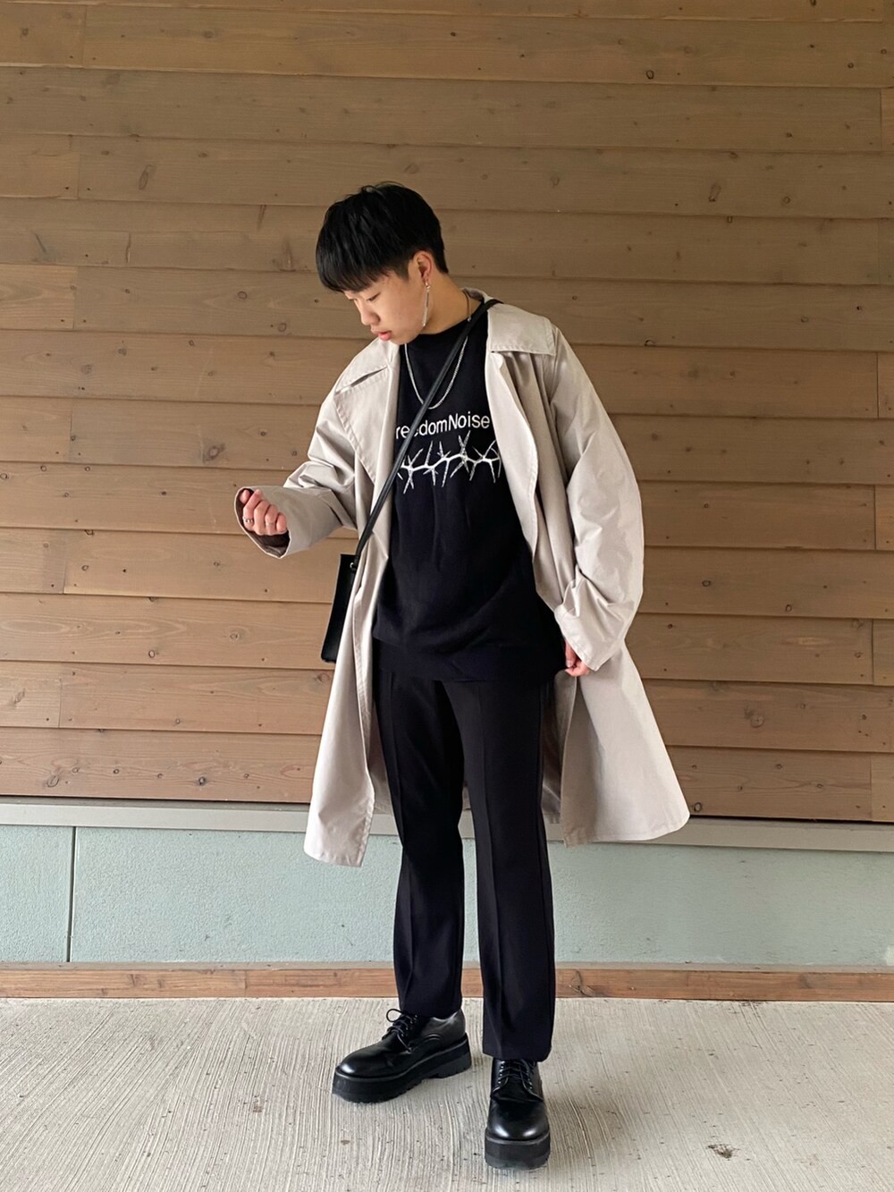 ブラック系のニット/セーター、ベージュ系のその他アウター、ブラック系のスラックスを着用したメンズの秋コーディネートの2枚目の写真