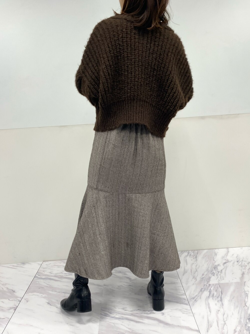 ホワイト系のショルダーバッグ、ブラウン系のカーディガン/ボレロ、ブラウン系のスカートを着用したレディースの秋コーディネートの4枚目の写真