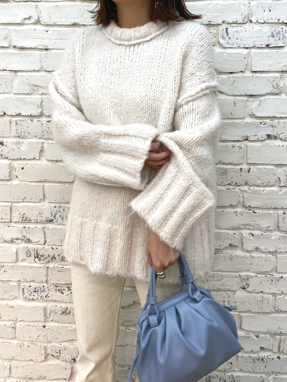 ホワイト系のデニムパンツ、ホワイト系のブーツ、ホワイト系のニット/セーターを着用したレディースの秋コーディネートの4枚目の写真