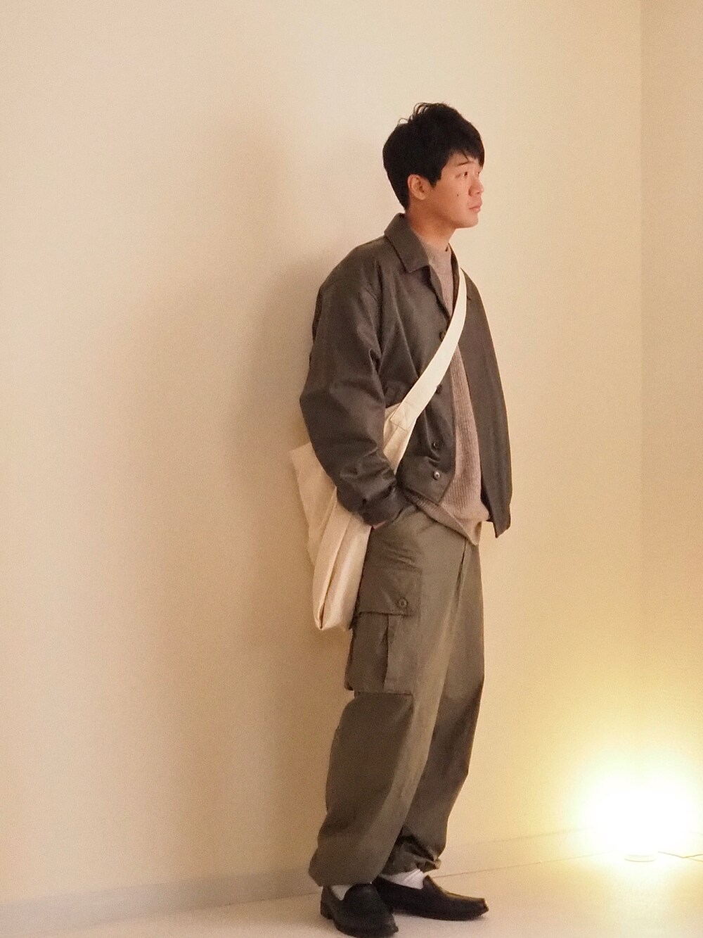 グリーン系のカーゴパンツ、ブラウン系のブルゾン、ベージュ系のニット/セーターを着用したメンズの冬コーディネートの2枚目の写真