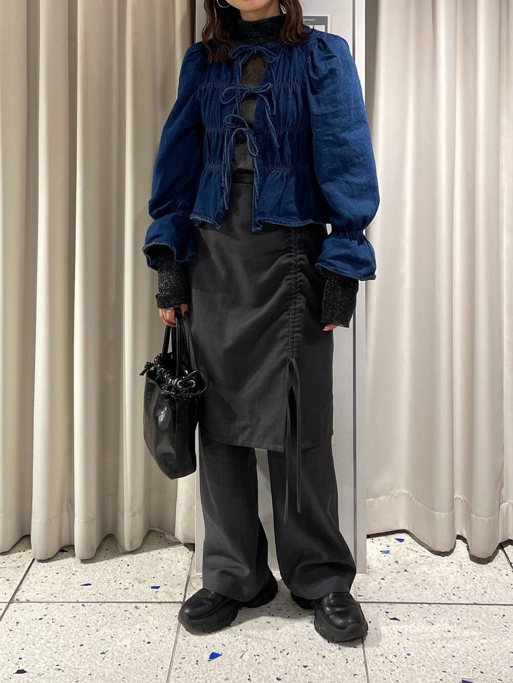 ブルー系のシャツ/ブラウス、ブラック系のブーツ、ブラック系のハンドバッグを着用したレディースの冬コーディネートの2枚目の写真