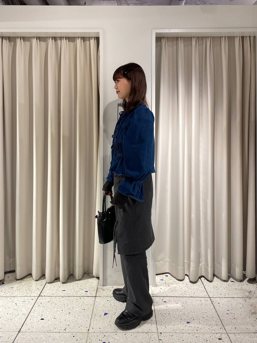 ブルー系のシャツ/ブラウス、ブラック系のブーツ、ブラック系のハンドバッグを着用したレディースの冬コーディネートの4枚目の写真