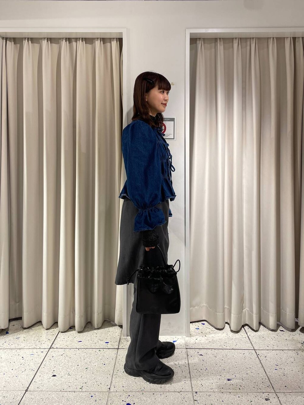 ブルー系のシャツ/ブラウス、ブラック系のブーツ、ブラック系のハンドバッグを着用したレディースの冬コーディネートの3枚目の写真