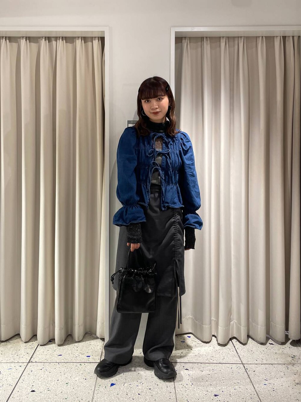 ブルー系のシャツ/ブラウス、ブラック系のブーツ、ブラック系のハンドバッグを着用したレディースの冬コーディネートの6枚目の写真