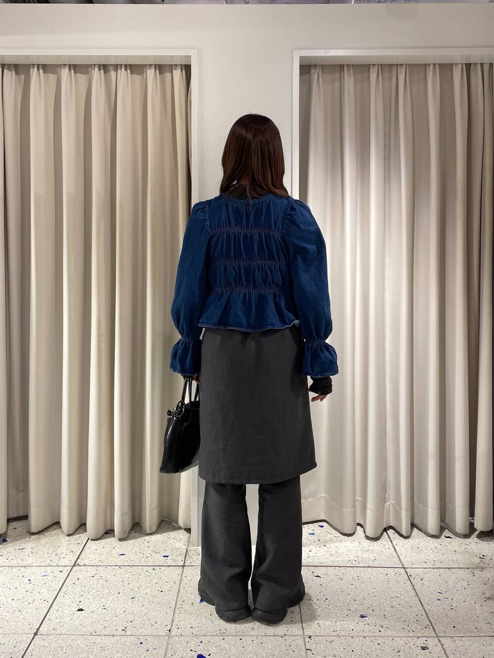 ブルー系のシャツ/ブラウス、ブラック系のブーツ、ブラック系のハンドバッグを着用したレディースの冬コーディネートの5枚目の写真