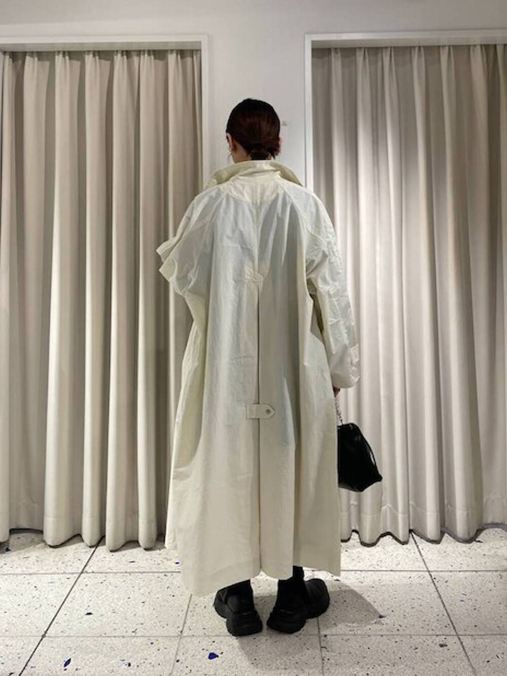 ブラック系のニット/セーター、ブラック系のブーツ、ホワイト系のブルゾンを着用したレディースの春コーディネートの4枚目の写真