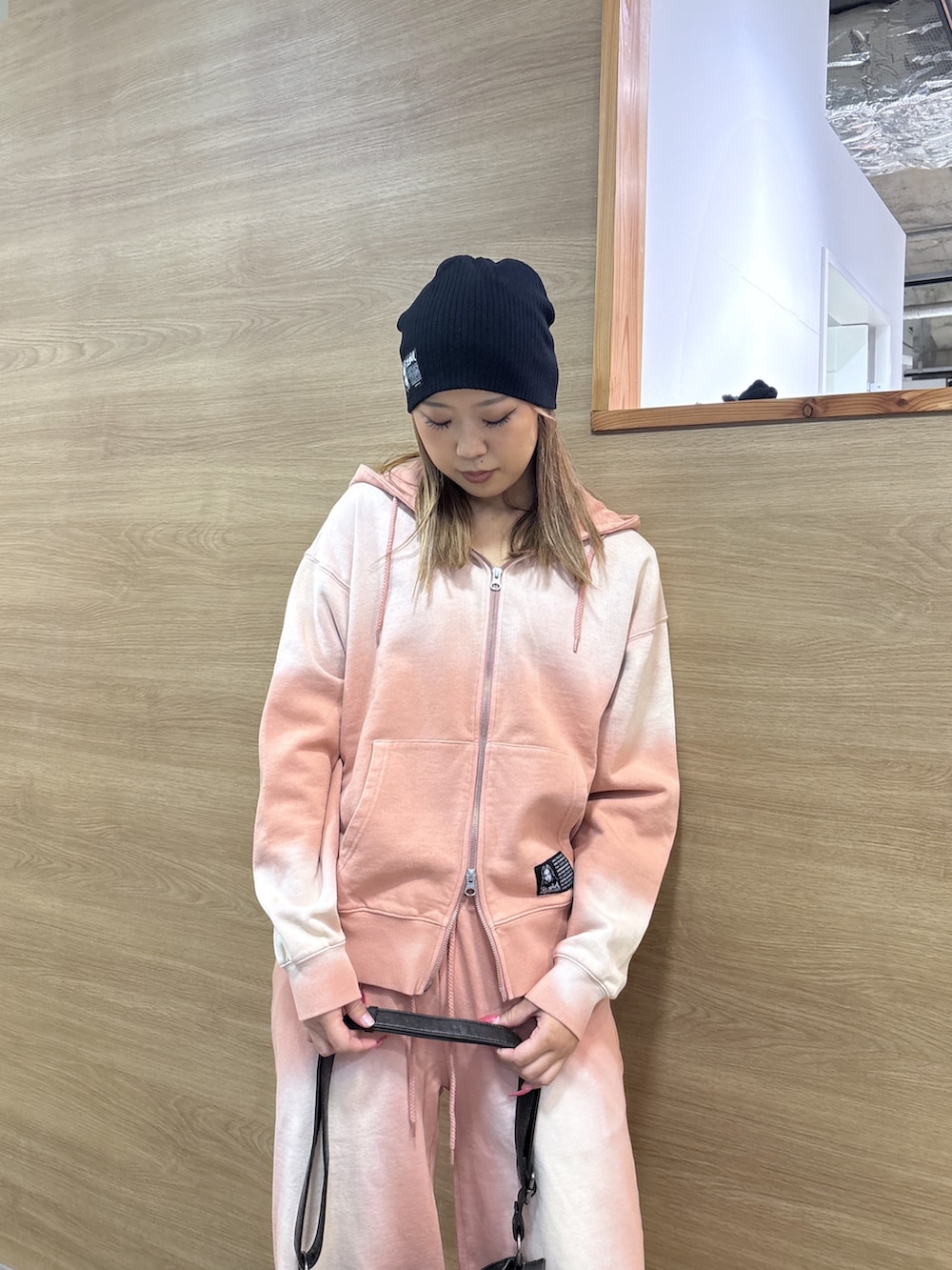 ピンク系のパーカー、ピンク系のスウェットパンツ、ブラック系のショルダーバッグを着用したレディースの冬コーディネートの4枚目の写真