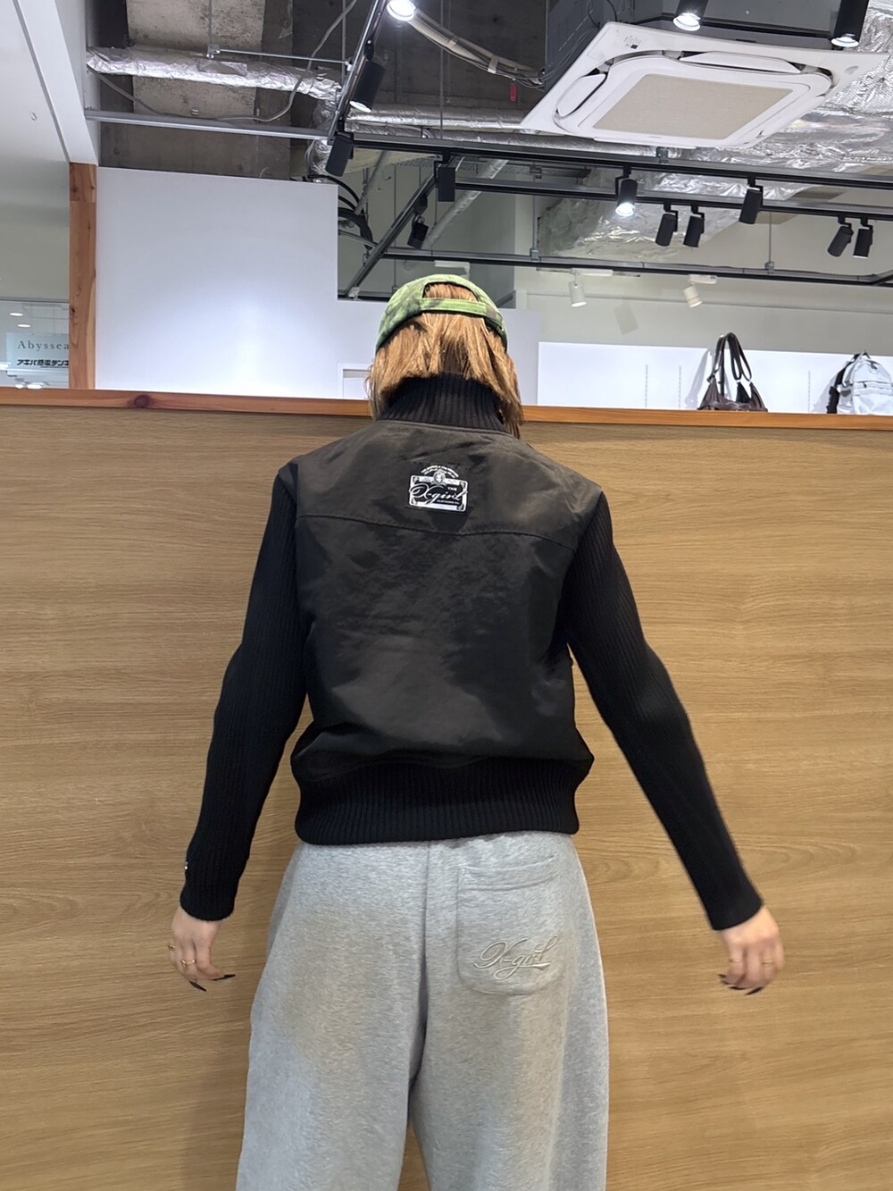 ブラック系のブルゾン、グレー系のスウェットパンツ、グリーン系のキャップを着用したレディースの冬コーディネートの5枚目の写真
