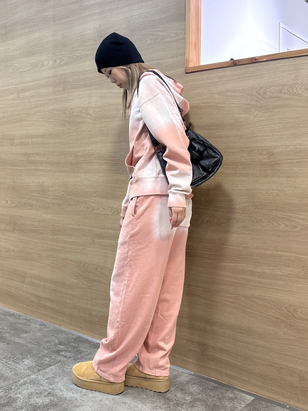 ピンク系のパーカー、ピンク系のスウェットパンツ、ブラック系のショルダーバッグを着用したレディースの冬コーディネートの2枚目の写真