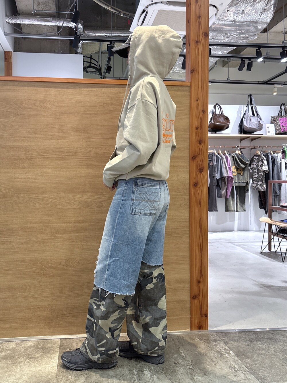 ベージュ系のパーカー、ブルー系のデニムパンツ、ブラック系のキャップを着用したレディースの春コーディネートの3枚目の写真