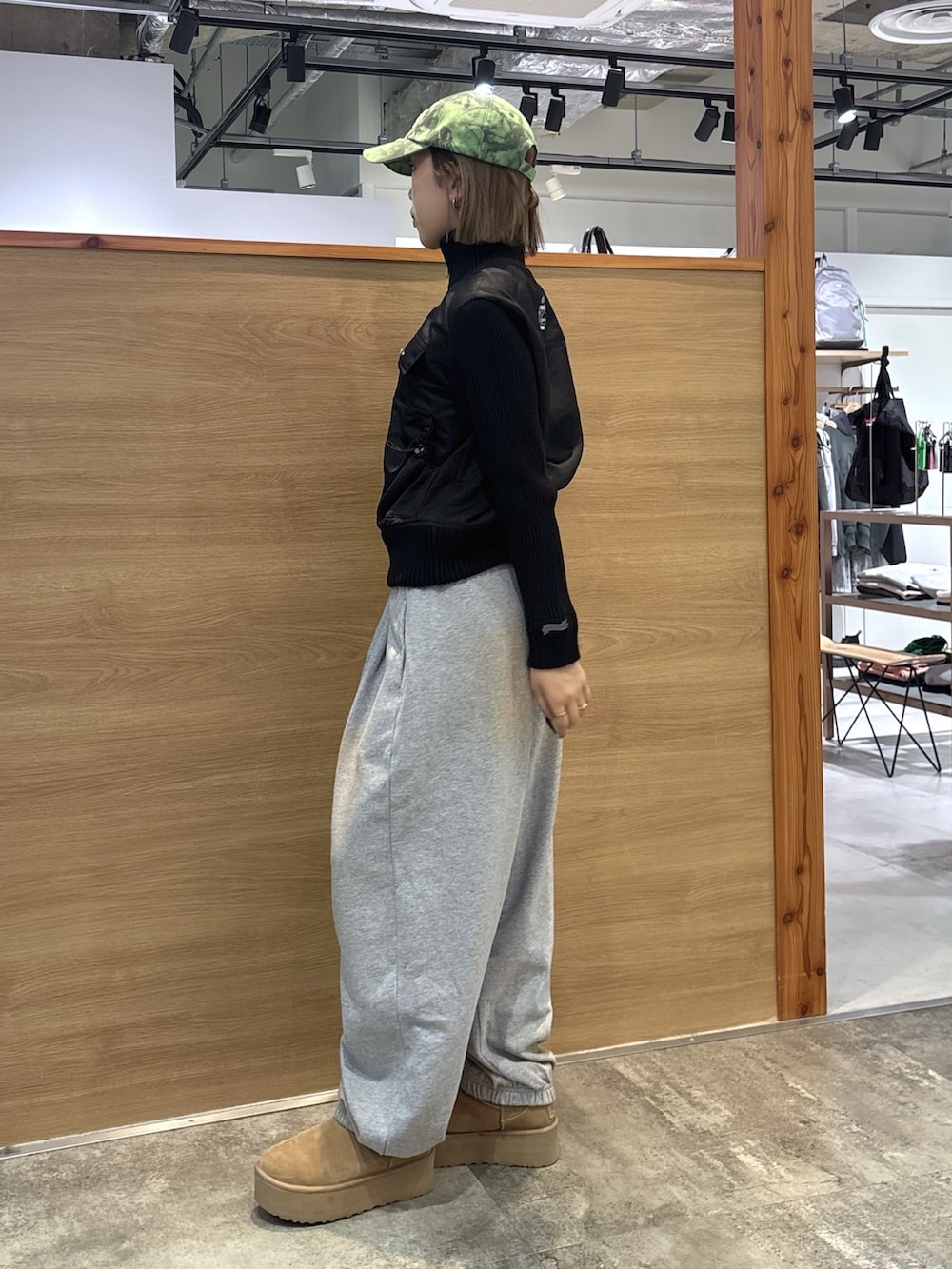 ブラック系のブルゾン、グレー系のスウェットパンツ、グリーン系のキャップを着用したレディースの冬コーディネートの3枚目の写真