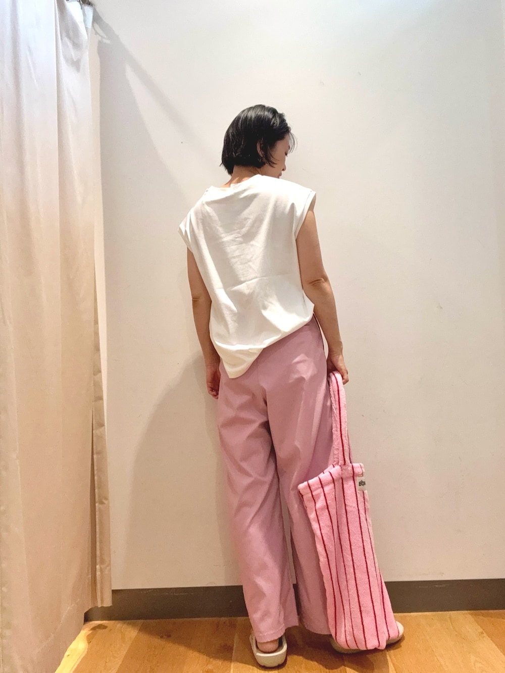 ホワイト系のTシャツ/カットソー、ピンク系のトートバッグ、ホワイト系のサンダルを着用したレディースの夏コーディネートの2枚目の写真