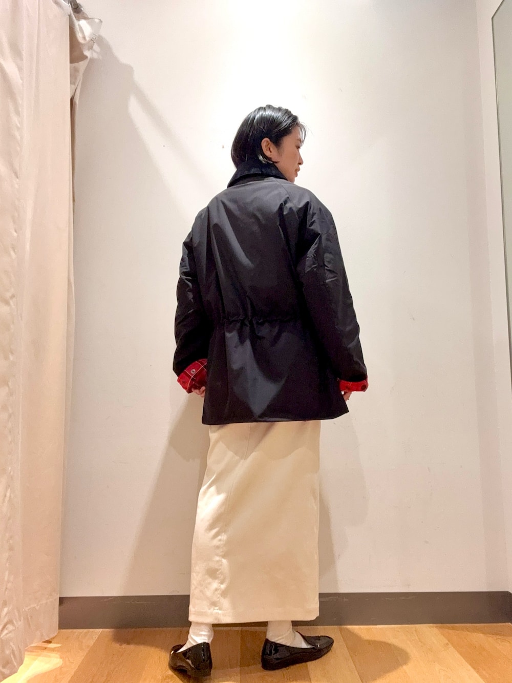 ホワイト系のスカート、ブラック系のその他アウター、グレー系のニット/セーターを着用したレディースの秋コーディネートの2枚目の写真