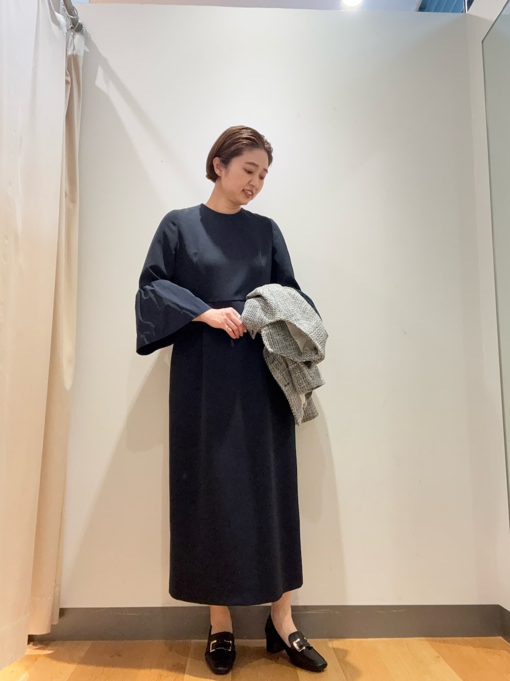 ブラック系のノーカラージャケット、ブルー系のワンピース、ブラック系のパンプスを着用したレディースの冬コーディネートの3枚目の写真