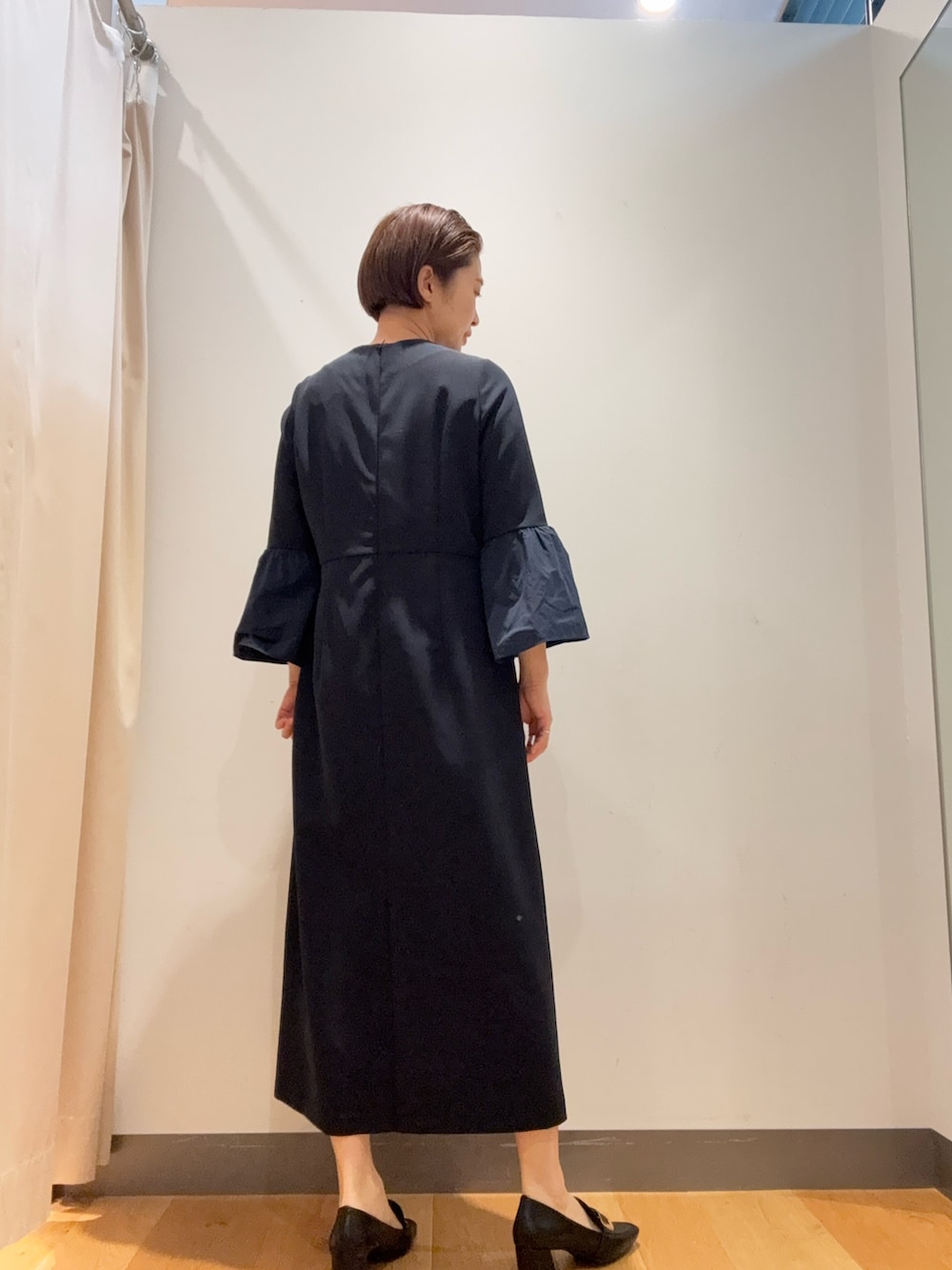 ブラック系のノーカラージャケット、ブルー系のワンピース、ブラック系のパンプスを着用したレディースの冬コーディネートの4枚目の写真