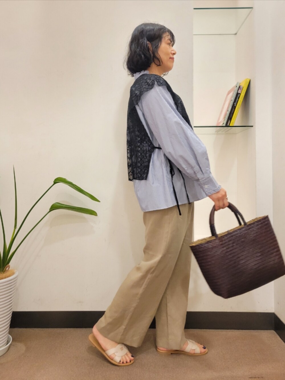 ブラウン系のトートバッグ、ベージュ系のその他パンツ、ホワイト系のサンダルを着用したレディースの夏コーディネートの4枚目の写真