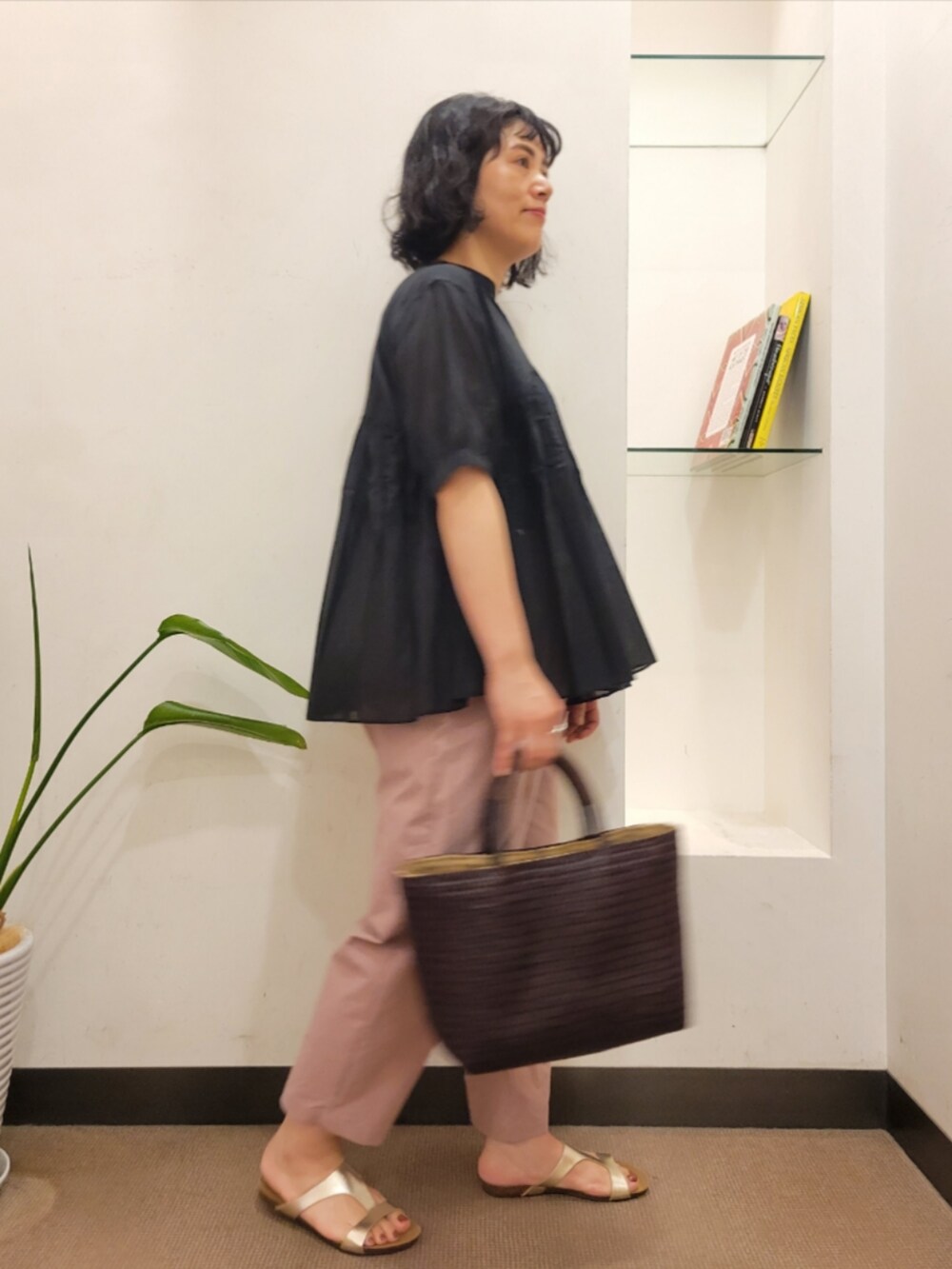ブラウン系のトートバッグ、ブラック系のシャツ/ブラウス、ゴールド系のサンダルを着用したレディースの夏コーディネートの4枚目の写真