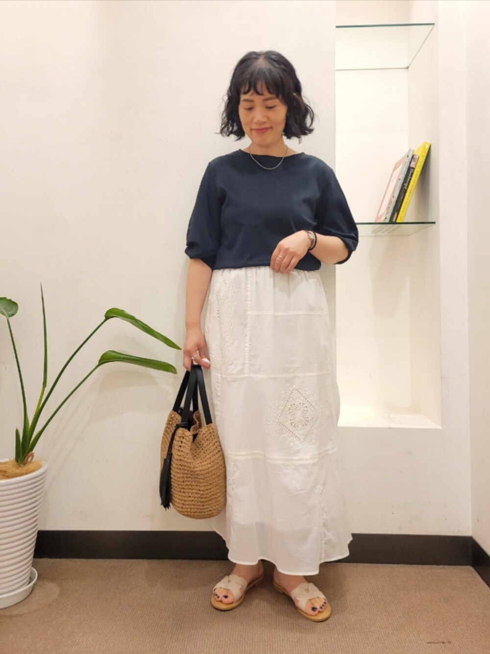 ブルー系のTシャツ/カットソー、ホワイト系のスカート、イエロー系のかごバッグを着用したレディースの夏コーディネートの2枚目の写真