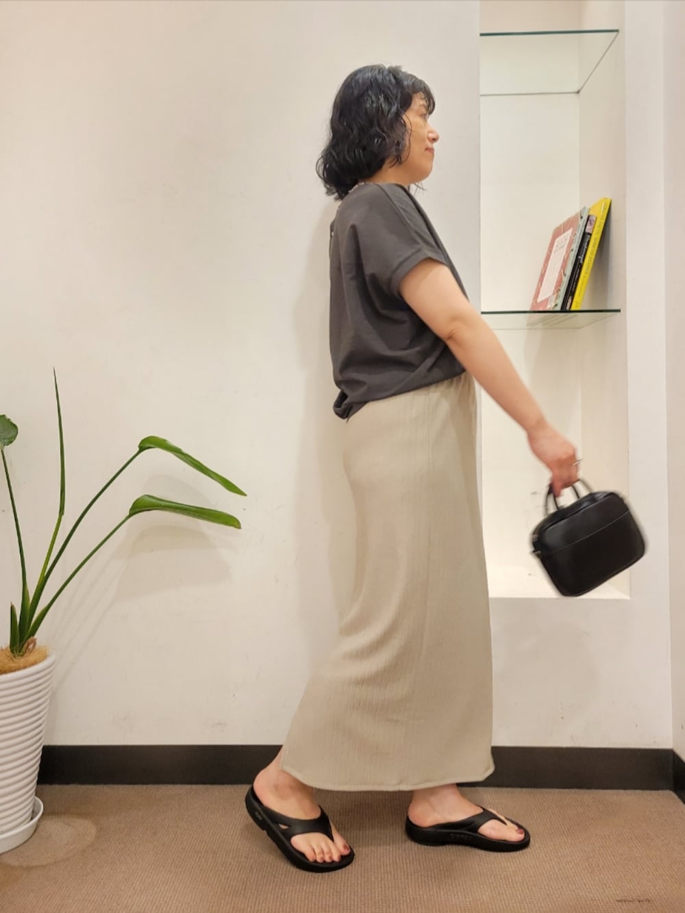ブラック系のショルダーバッグ、グレー系のTシャツ/カットソー、ベージュ系のスカートを着用したレディースの夏コーディネートの4枚目の写真