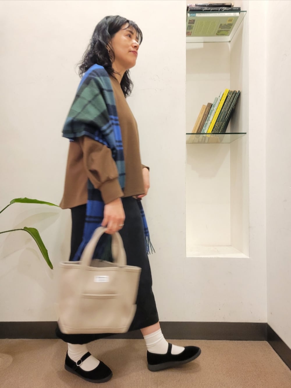 ベージュ系のトートバッグ、ブラック系のスカート、ブラック系のその他シューズを着用したレディースの秋コーディネートの2枚目の写真