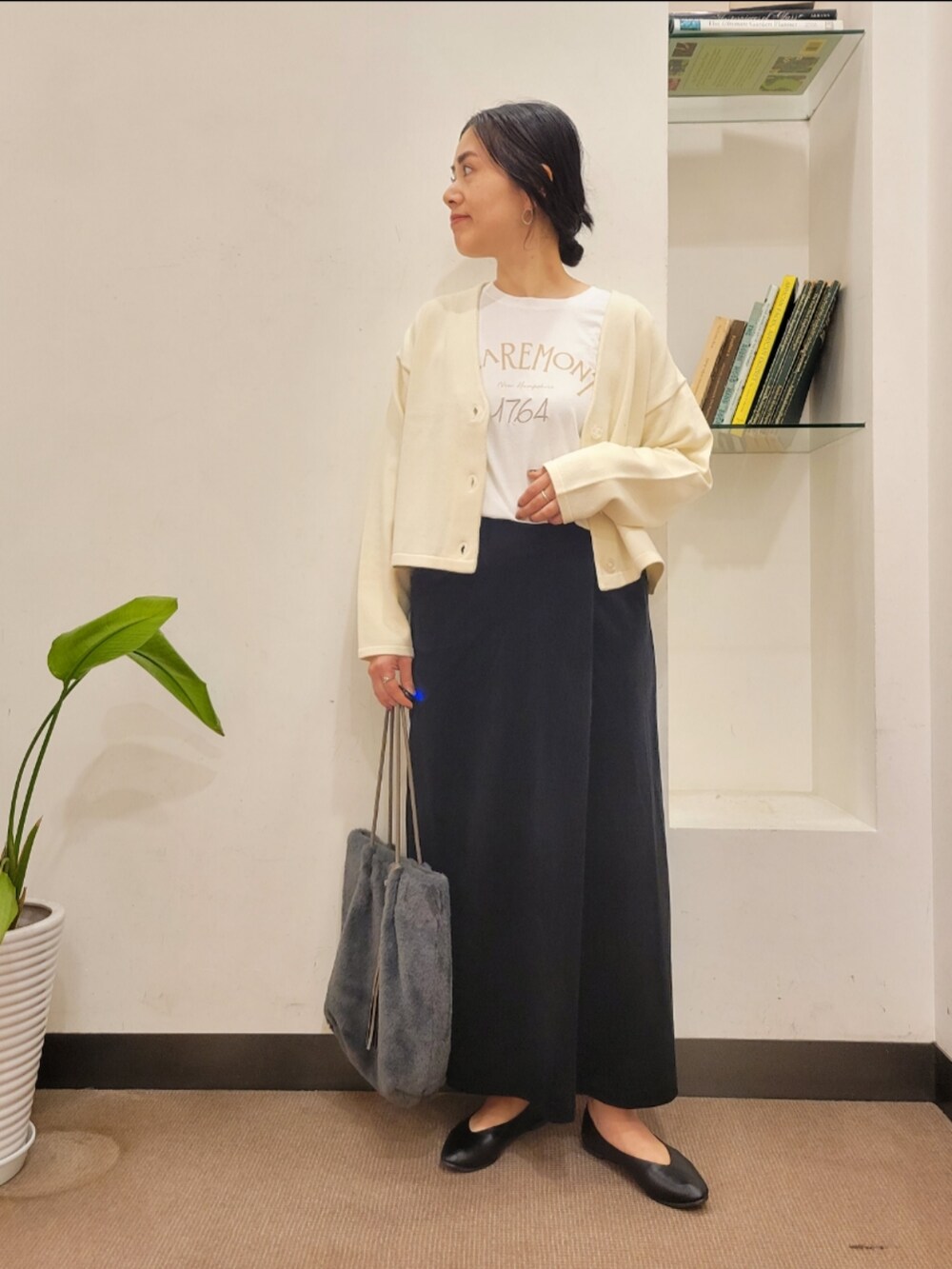 ブラック系のパンプス、グレー系のトートバッグ、ホワイト系のカーディガン/ボレロを着用したレディースの秋コーディネートの2枚目の写真