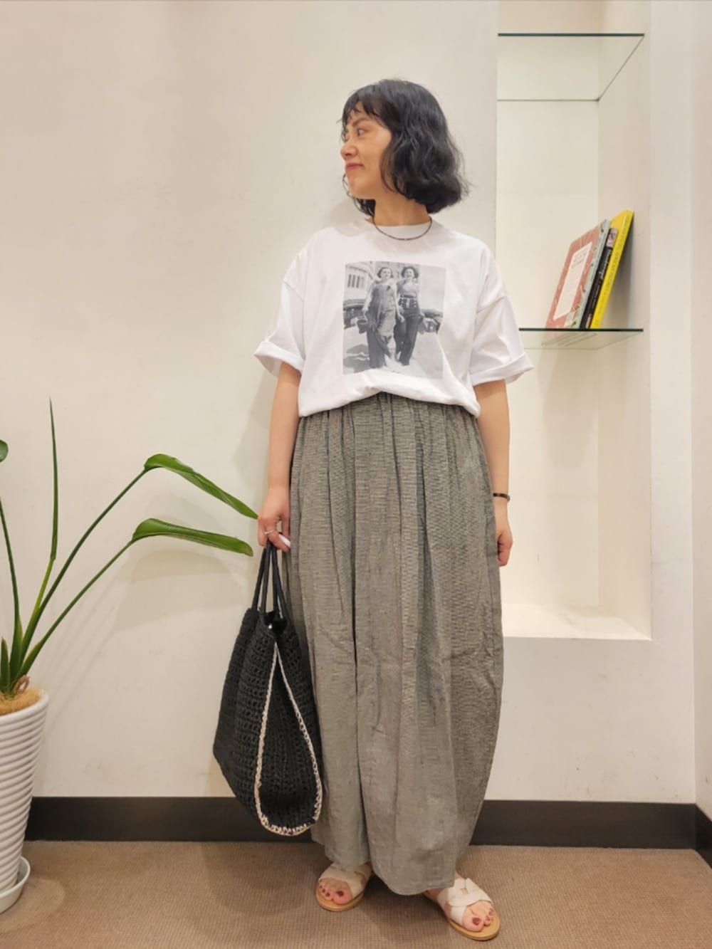ホワイト系のTシャツ/カットソー、ブラック系のトートバッグ、ホワイト系のサンダルを着用したレディースの夏コーディネートの2枚目の写真