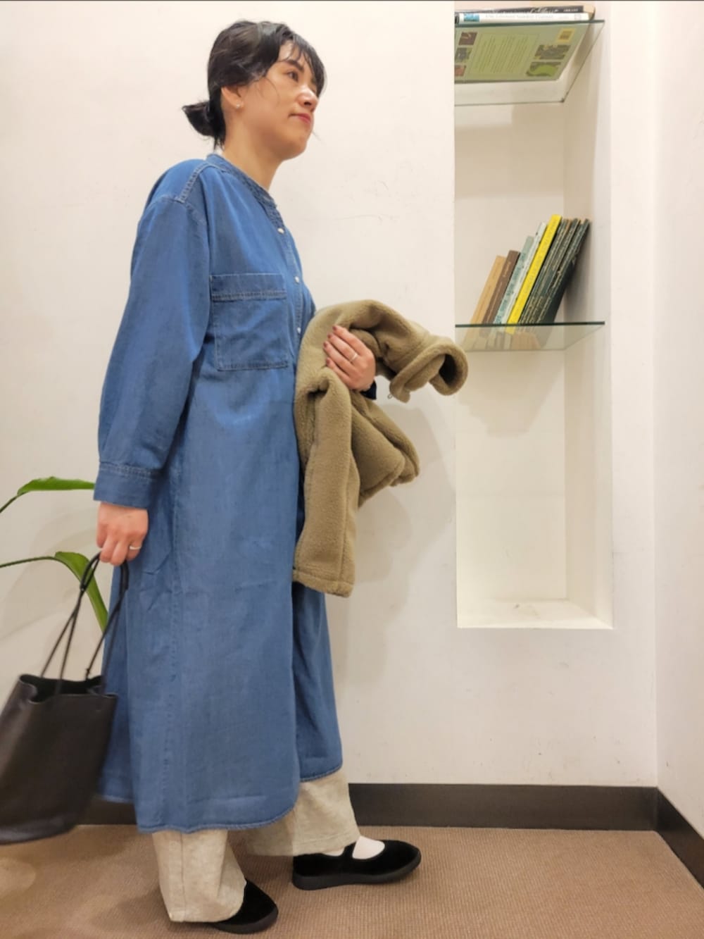 ブラック系のショルダーバッグ、ベージュ系のブルゾン、ブルー系のワンピースを着用したレディースの秋コーディネートの5枚目の写真