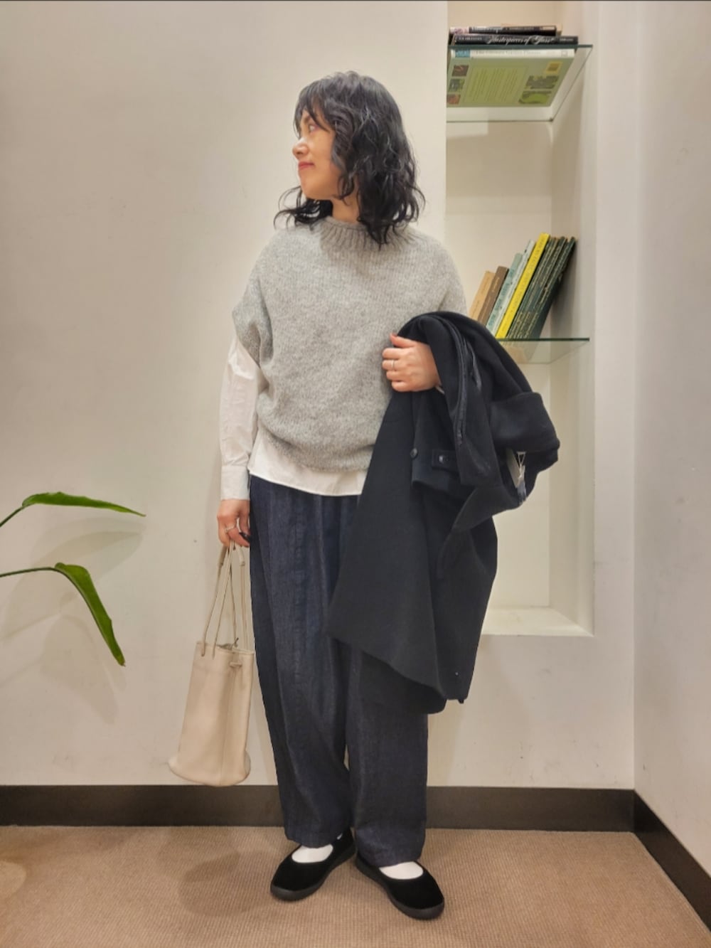 グレー系のショルダーバッグ、ブラック系のその他シューズ、ブルー系のデニムパンツを着用したレディースの秋コーディネートの4枚目の写真