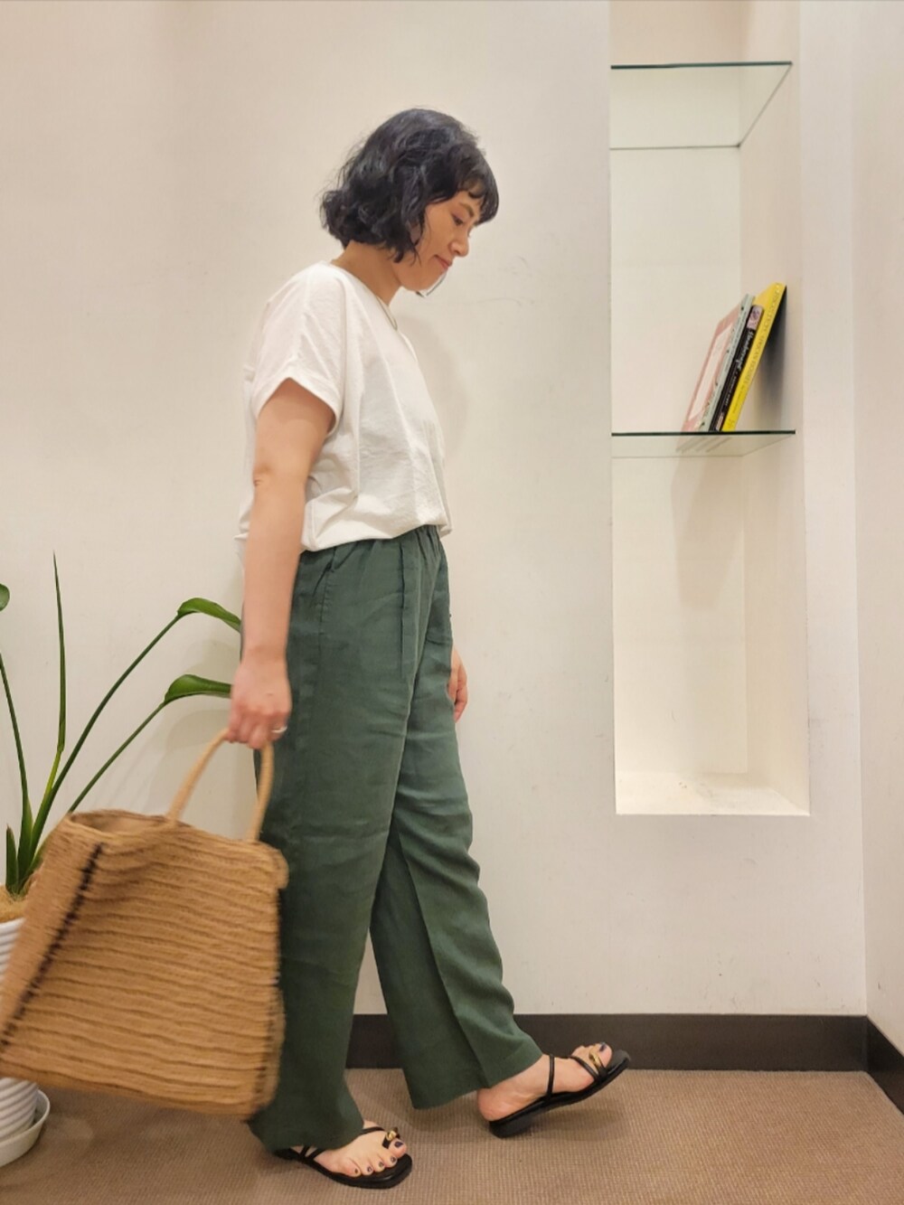 ベージュ系のトートバッグ、ホワイト系のTシャツ/カットソー、グリーン系のその他パンツを着用したレディースの夏コーディネートの3枚目の写真