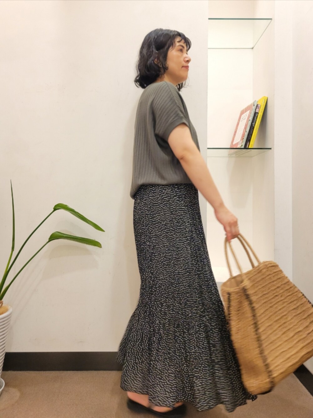 ベージュ系のトートバッグ、グレー系のTシャツ/カットソー、ブラック系のスカートを着用したレディースの夏コーディネートの4枚目の写真