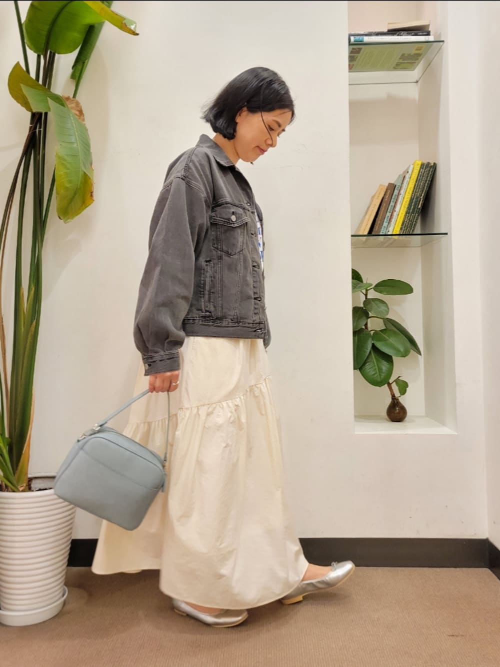 シルバー系のバレエシューズ、ブルー系のショルダーバッグ、ブラック系のデニムジャケットを着用したレディースの春コーディネートの2枚目の写真