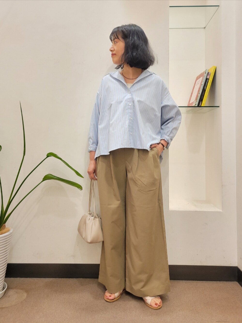 グレー系のショルダーバッグ、ベージュ系のその他パンツ、ブルー系のシャツ/ブラウスを着用したレディースの夏コーディネートの2枚目の写真