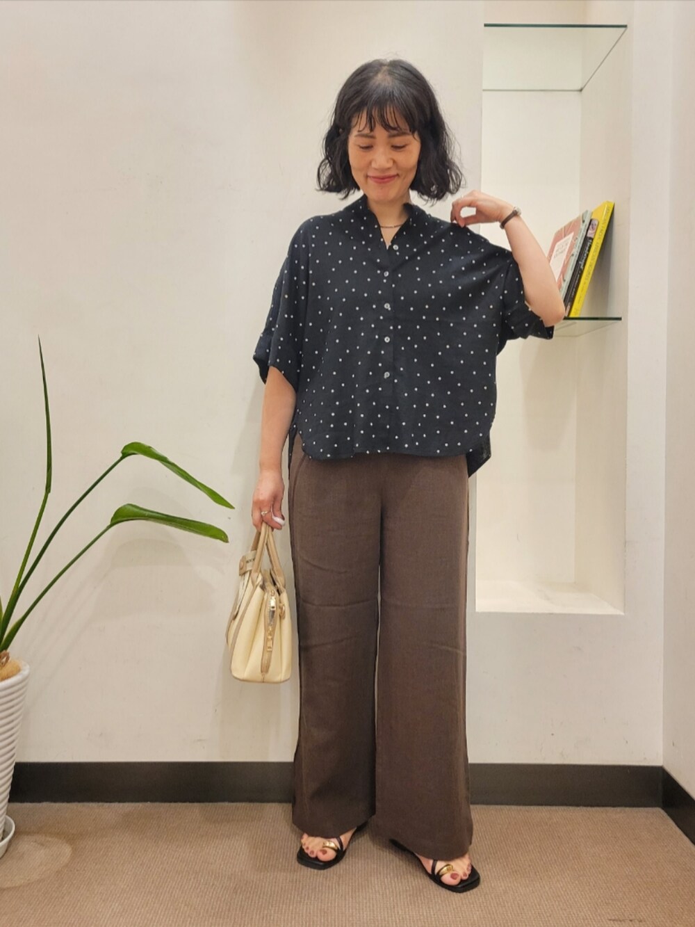 ブラック系のシャツ/ブラウス、ブラウン系のその他パンツ、ホワイト系のハンドバッグを着用したレディースの夏コーディネートの2枚目の写真