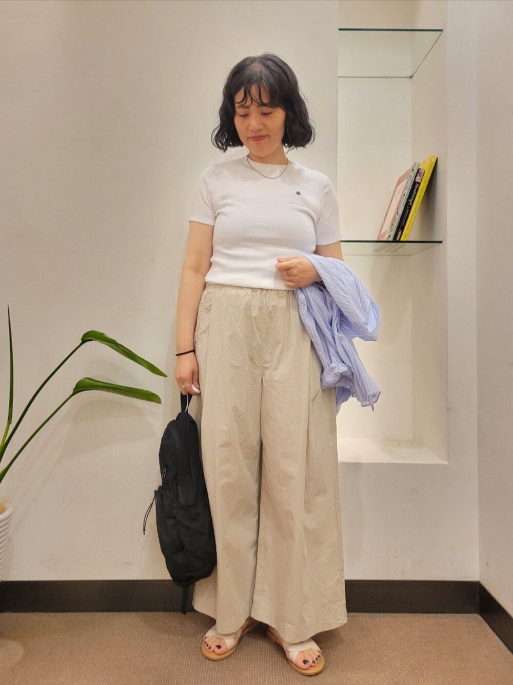 ホワイト系のTシャツ/カットソー、ブラック系のバックパック/リュック、ホワイト系のサンダルを着用したレディースの夏コーディネートの5枚目の写真