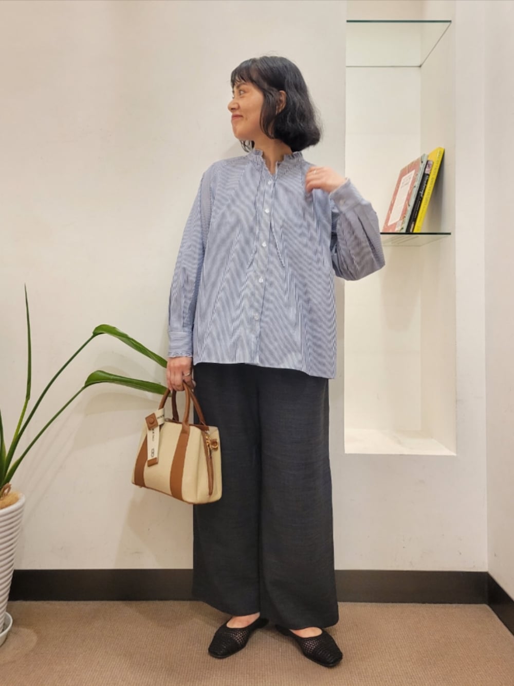 グレー系のその他パンツ、ブラック系のバレエシューズ、ホワイト系のハンドバッグを着用したレディースの夏コーディネートの2枚目の写真