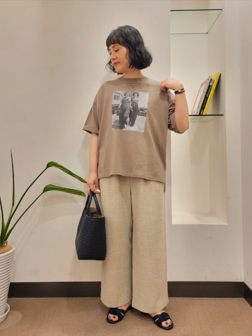 ブルー系のトートバッグ、ブラウン系のTシャツ/カットソー、ベージュ系のその他パンツを着用したレディースの夏コーディネートの2枚目の写真