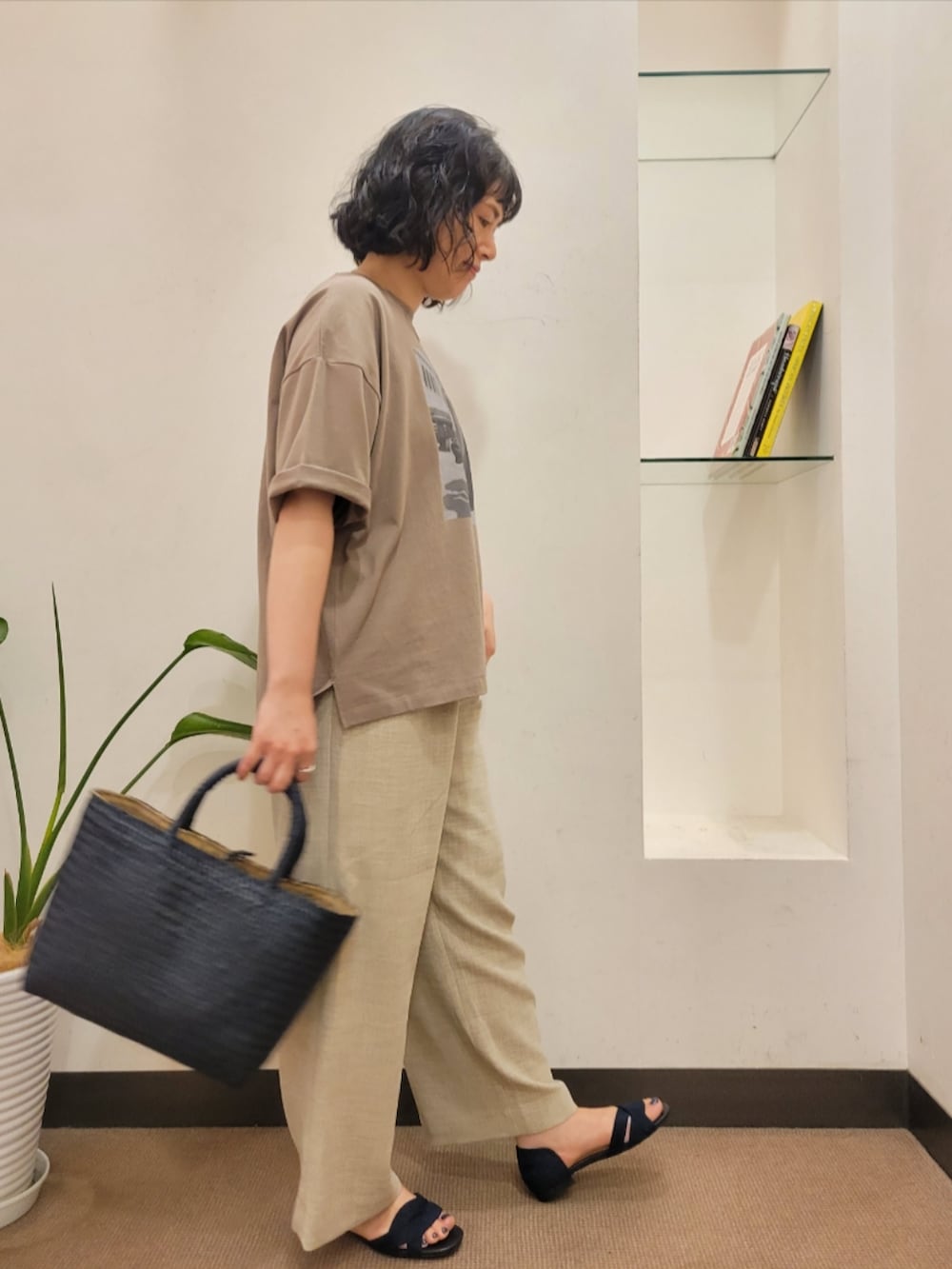 ブルー系のトートバッグ、ブラウン系のTシャツ/カットソー、ベージュ系のその他パンツを着用したレディースの夏コーディネートの3枚目の写真