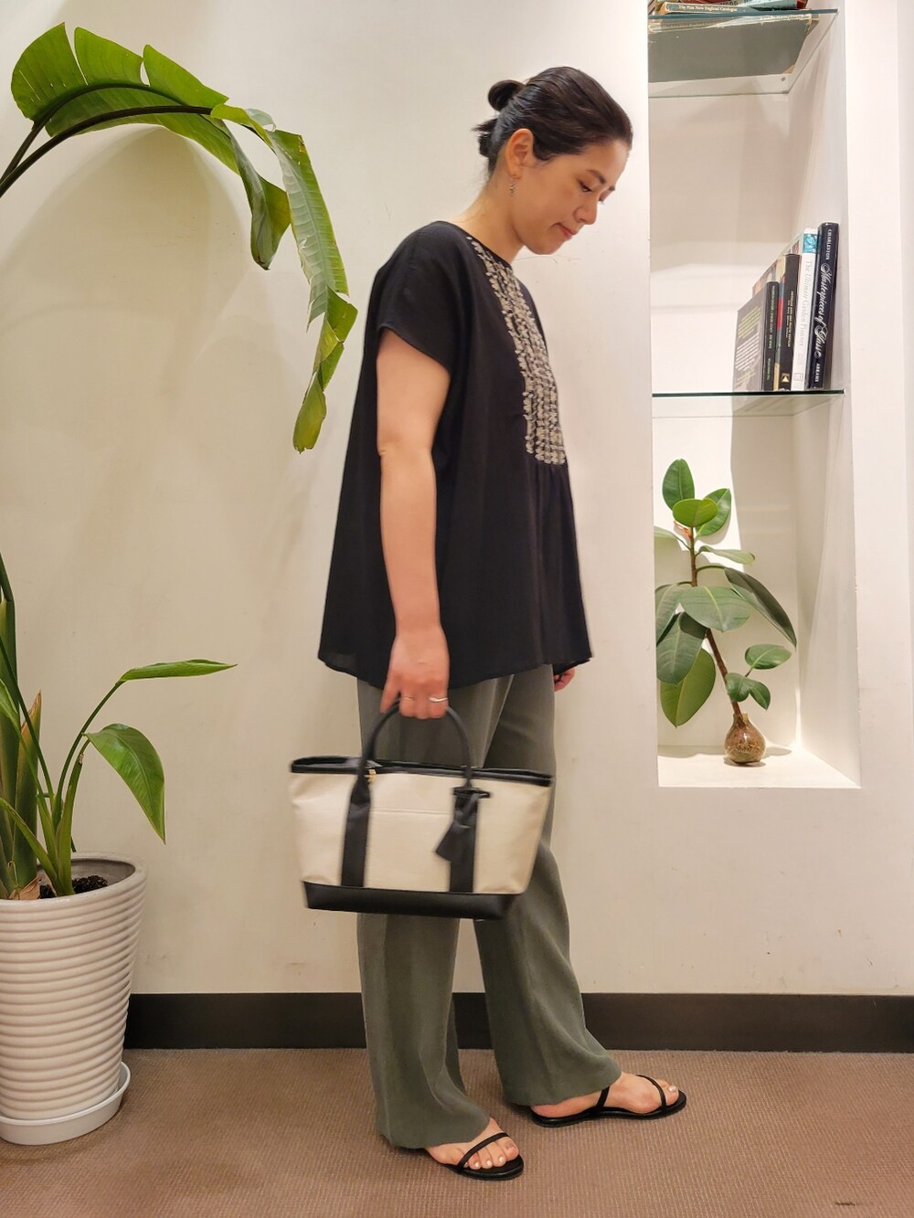 ブラック系のサンダル、ホワイト系のトートバッグ、グリーン系のその他パンツを着用したレディースの夏コーディネートの2枚目の写真