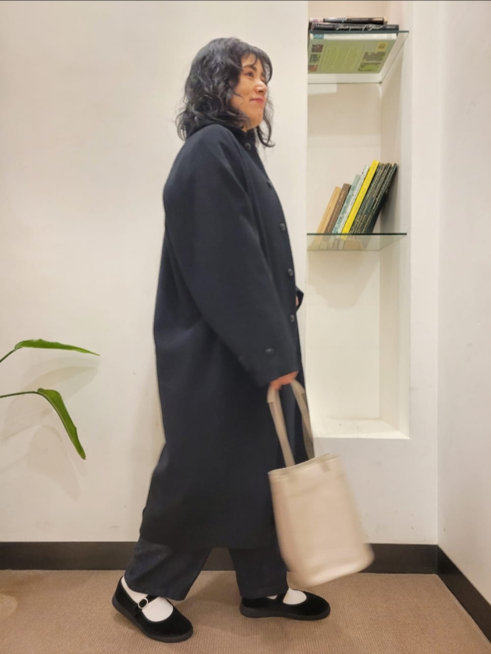 グレー系のショルダーバッグ、ブラック系のその他シューズ、ブルー系のデニムパンツを着用したレディースの秋コーディネートの2枚目の写真