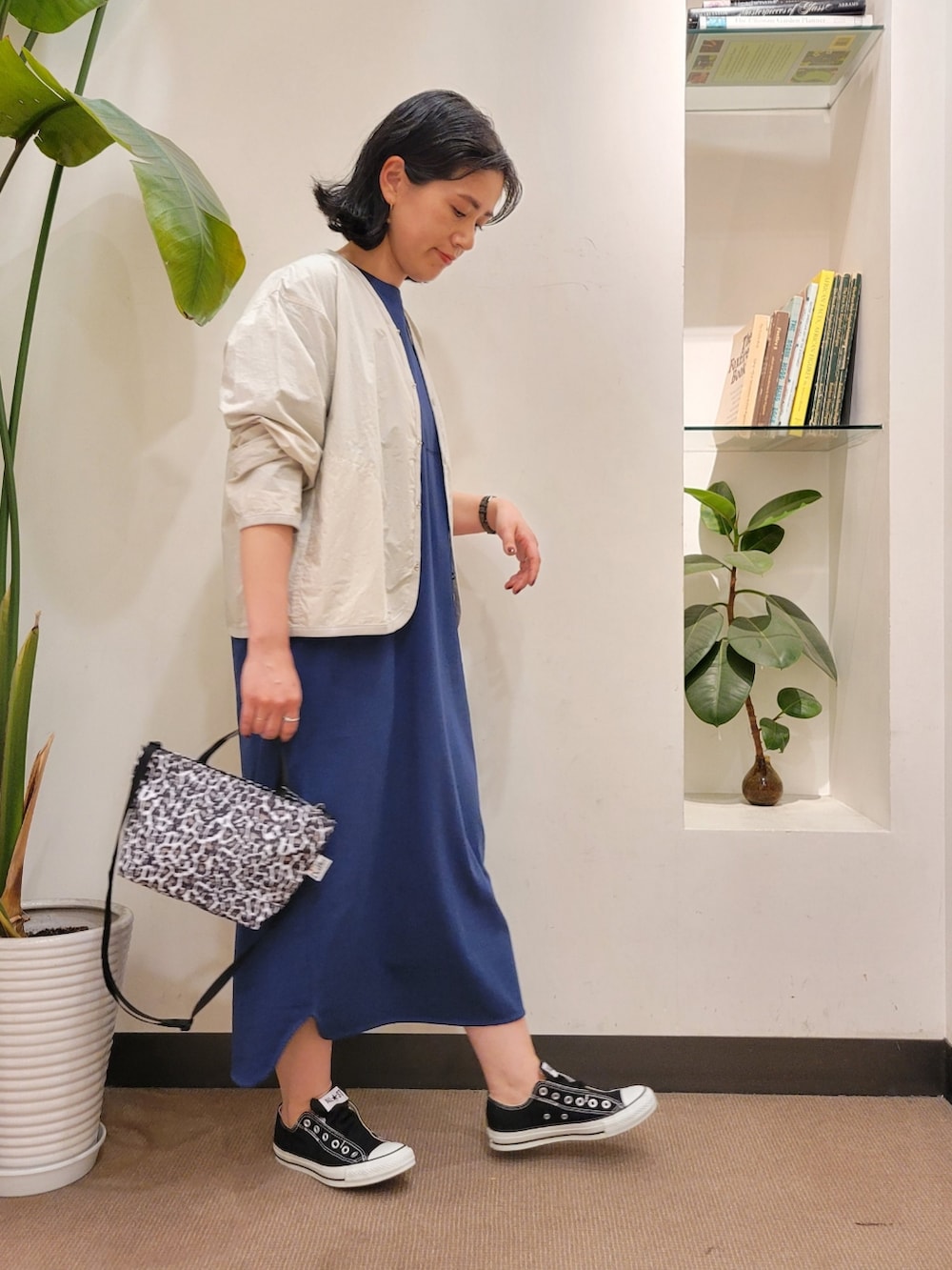 ホワイト系のショルダーバッグ、グレー系のノーカラージャケット、ブルー系のワンピースを着用したレディースの春コーディネートの2枚目の写真