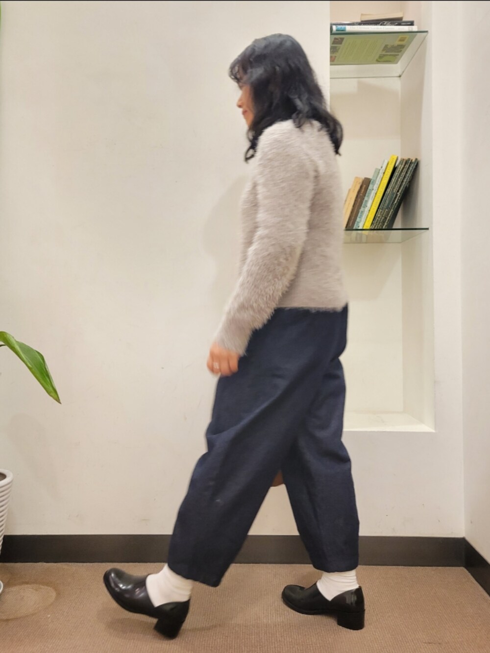 ブラック系のレインシューズ、ブラウン系のショルダーバッグ、グレー系のニット/セーターを着用したレディースの冬コーディネートの4枚目の写真