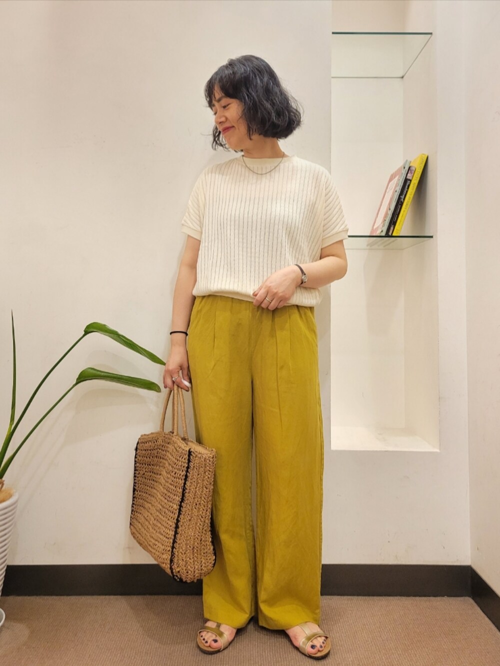 ホワイト系のTシャツ/カットソー、イエロー系のその他パンツ、ベージュ系のトートバッグを着用したレディースの夏コーディネートの2枚目の写真