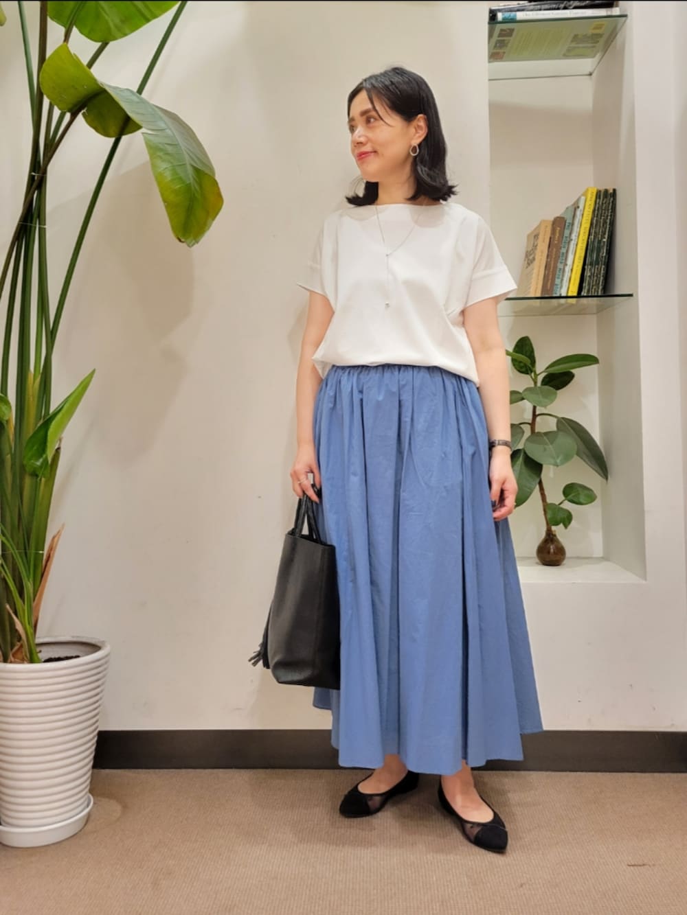 ブラック系のバレエシューズ、ブラック系のトートバッグ、ブルー系のスカートを着用したレディースの夏コーディネートの2枚目の写真