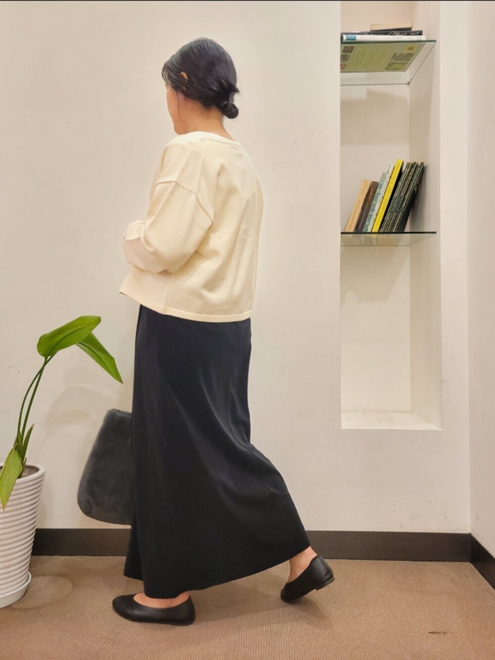 ブラック系のパンプス、グレー系のトートバッグ、ホワイト系のカーディガン/ボレロを着用したレディースの秋コーディネートの4枚目の写真