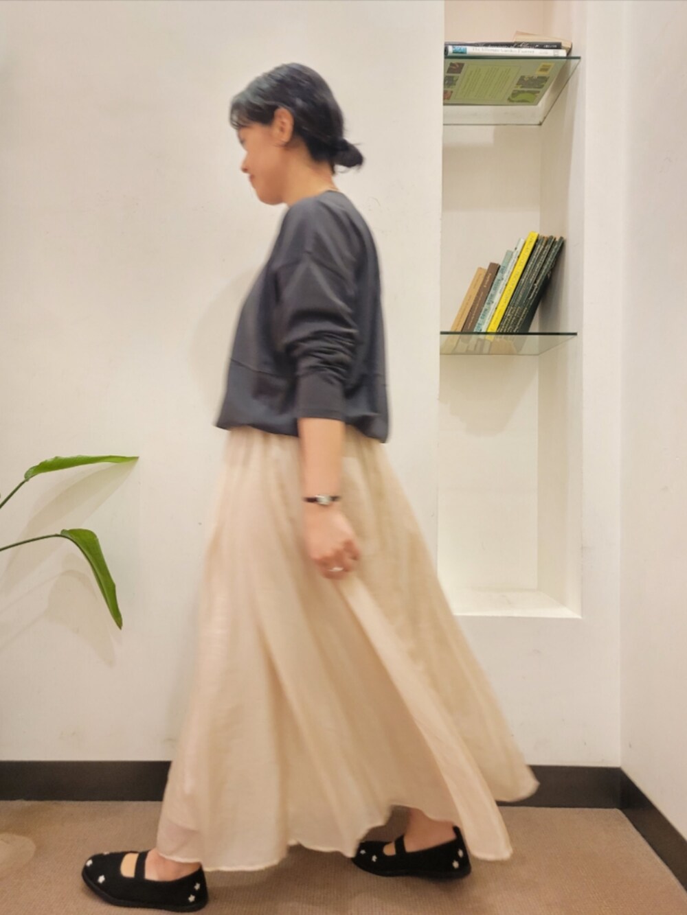 グレー系のTシャツ/カットソー、ベージュ系のスカート、ブラック系のスニーカーを着用したレディースの秋コーディネートの4枚目の写真