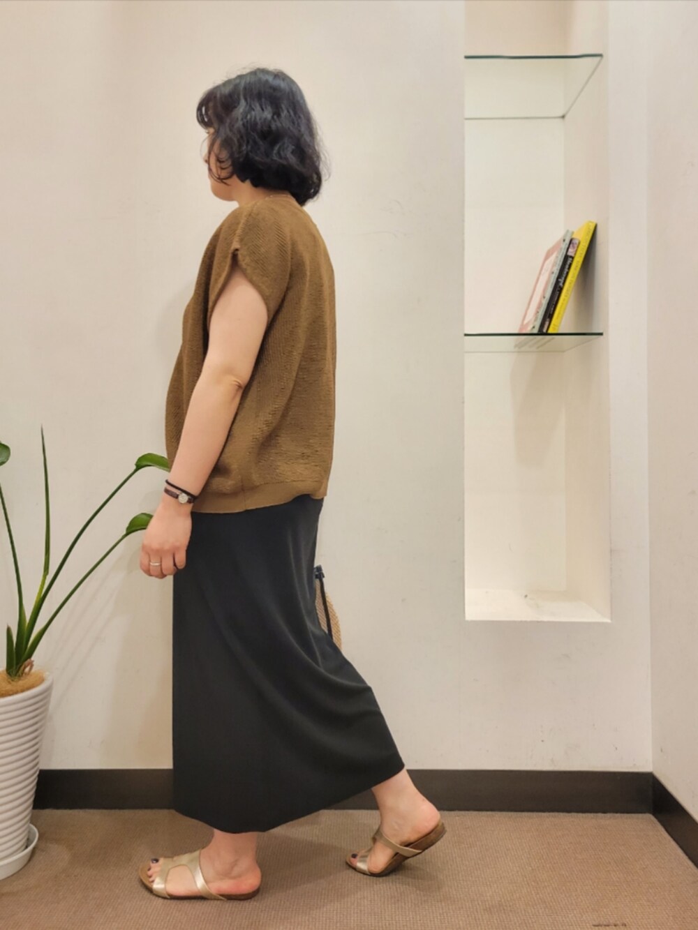 ブラック系のワンピース、ブラウン系のベスト、ブラック系のショルダーバッグを着用したレディースの夏コーディネートの4枚目の写真