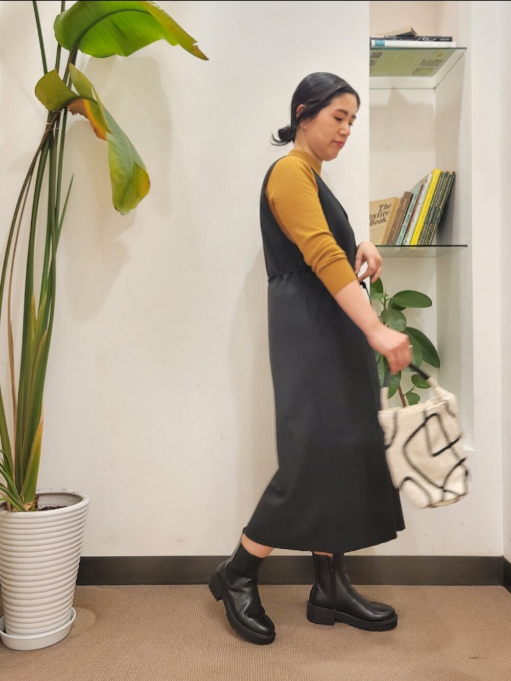 ホワイト系のショルダーバッグ、ブラック系のワンピース、イエロー系のニット/セーターを着用したレディースの秋コーディネートの3枚目の写真