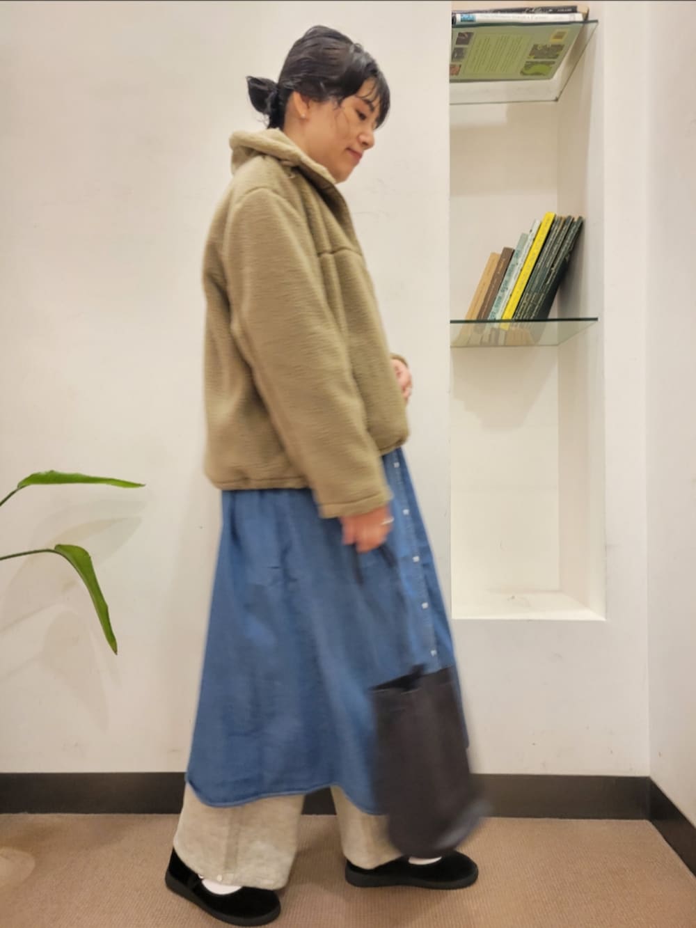 ブラック系のショルダーバッグ、ベージュ系のブルゾン、ブルー系のワンピースを着用したレディースの秋コーディネートの2枚目の写真