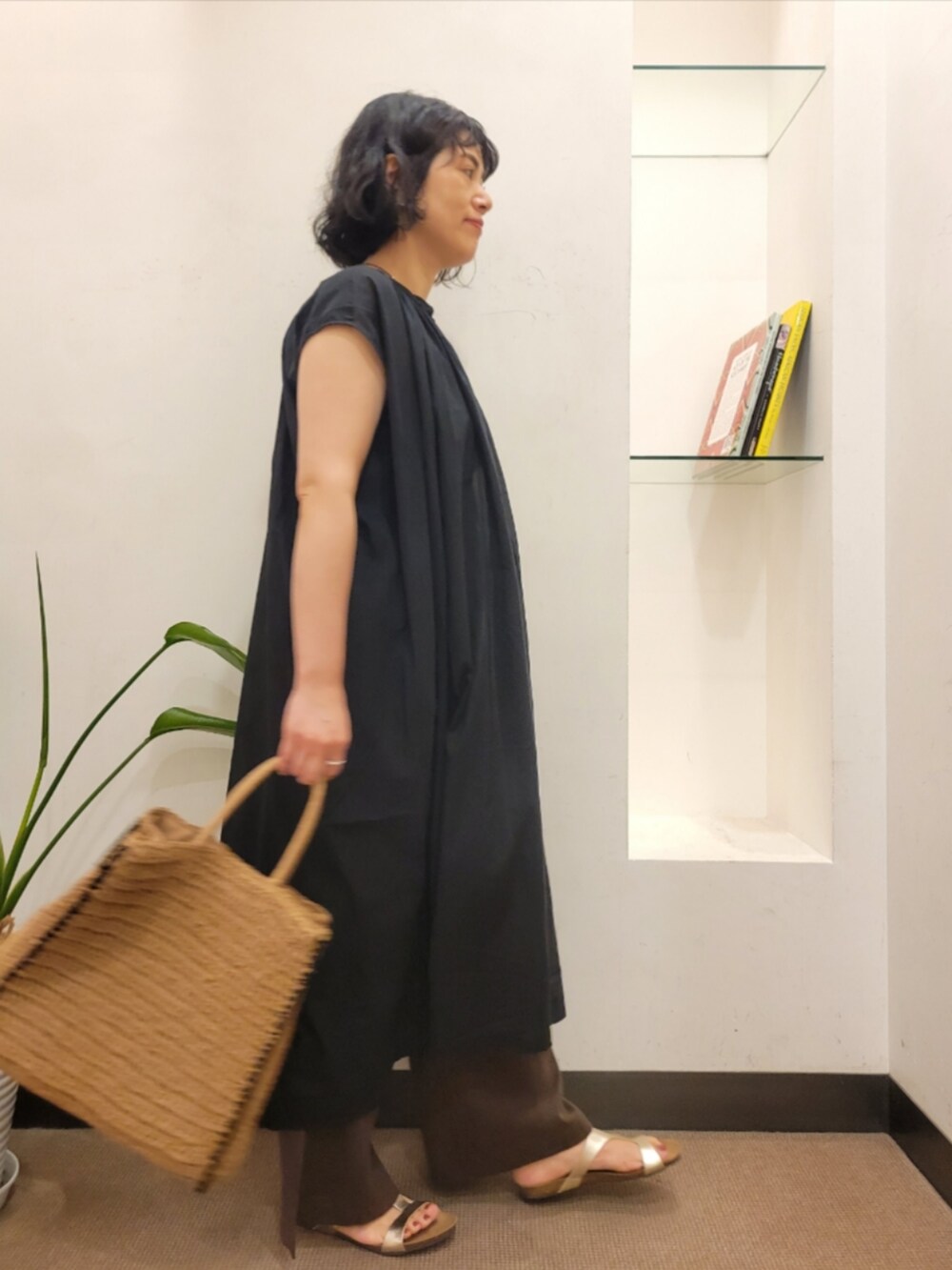 ベージュ系のトートバッグ、ブラック系のワンピース、ブラウン系のその他パンツを着用したレディースの夏コーディネートの3枚目の写真