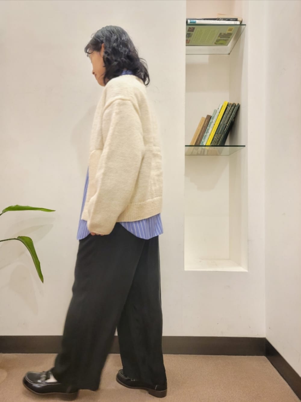 ブラック系のハンドバッグ、ブラック系のローファー、ホワイト系のニット/セーターを着用したレディースの秋コーディネートの3枚目の写真